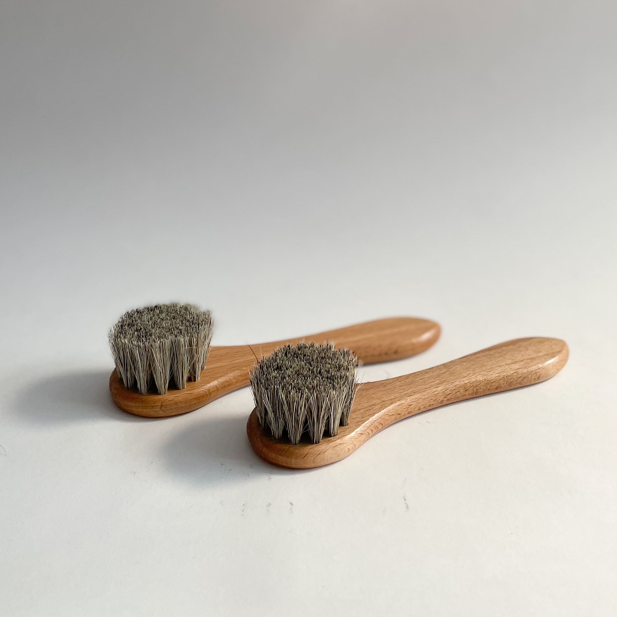 Two hosehair dauber brushes on white background